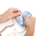 Woman cleaning a jewellery with a special cloth